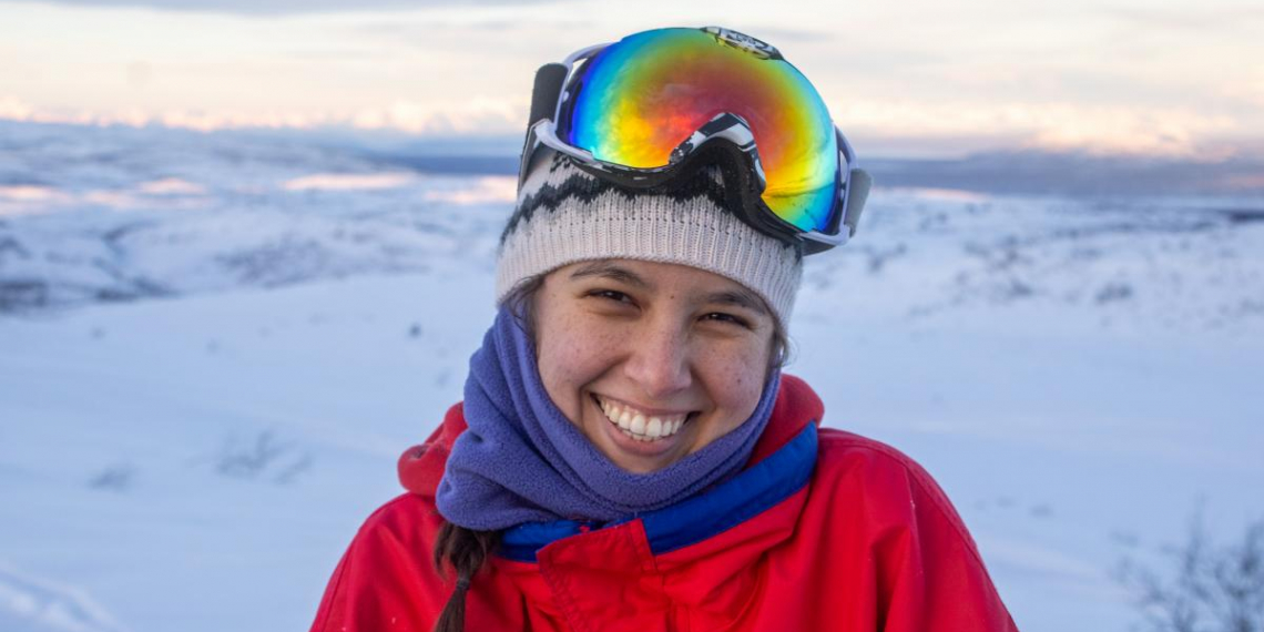 Josephine Vonk smiling, wearing ski goggles and winter clothing against a snowy backdrop.