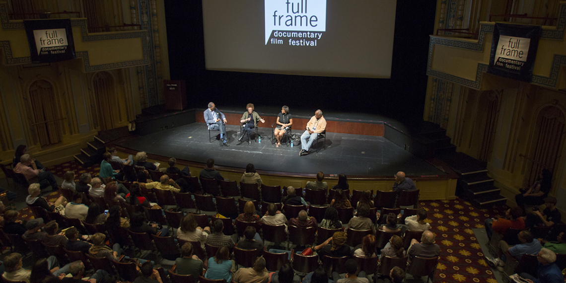 Four panelists speak on stage in front of an audience at the Full Frame festival.